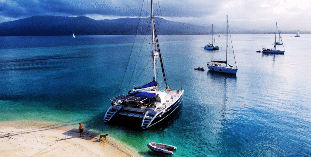 A beautiful "arrival" shot. The Nomade seen from the air waiting in the turquoise water. The "prize" at the end of the journey